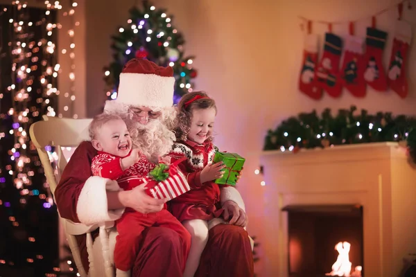 Kids and Santa at fire place on Christmas eve — 图库照片