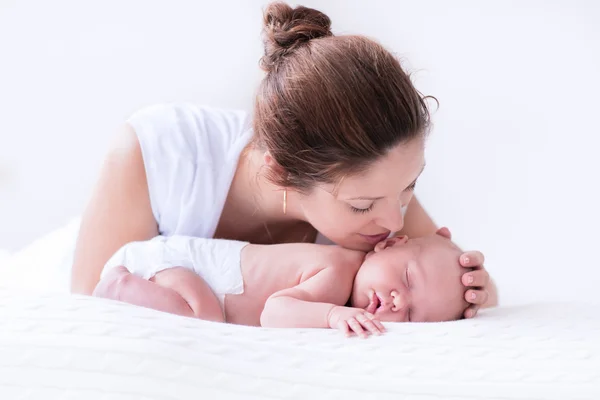 Junge Mutter und Neugeborenes im weißen Schlafzimmer — Stockfoto