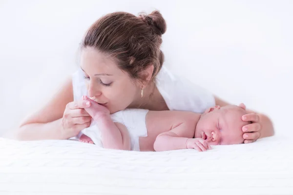 Jovem mãe e bebê recém-nascido no quarto branco — Fotografia de Stock