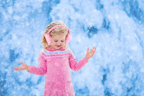 Kleines Mädchen fängt Schneeflocken — Stockfoto