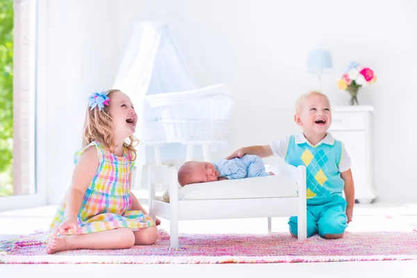 Niños jugando con su hermano recién nacido —  Fotos de Stock