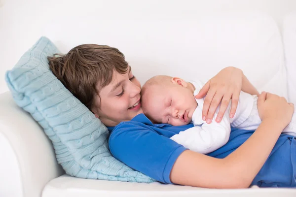 Menino segurando seu irmão bebê recém-nascido — Fotografia de Stock