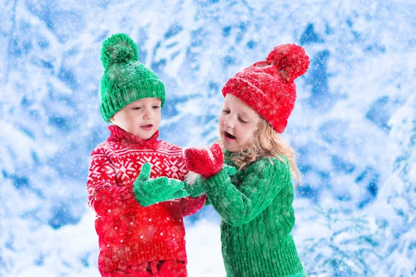 Kids playing in snowy winter forest — Stock Photo, Image