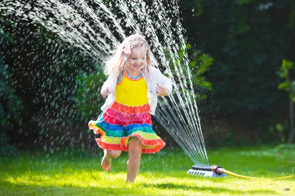 Niños jugando con aspersor de jardín —  Fotos de Stock