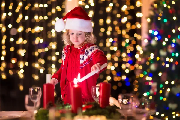 Child lighting a candle at Christmas dinner — Stock Photo, Image