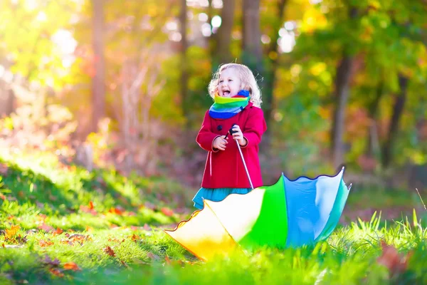 Child playing in autumn rainy park — Stockfoto