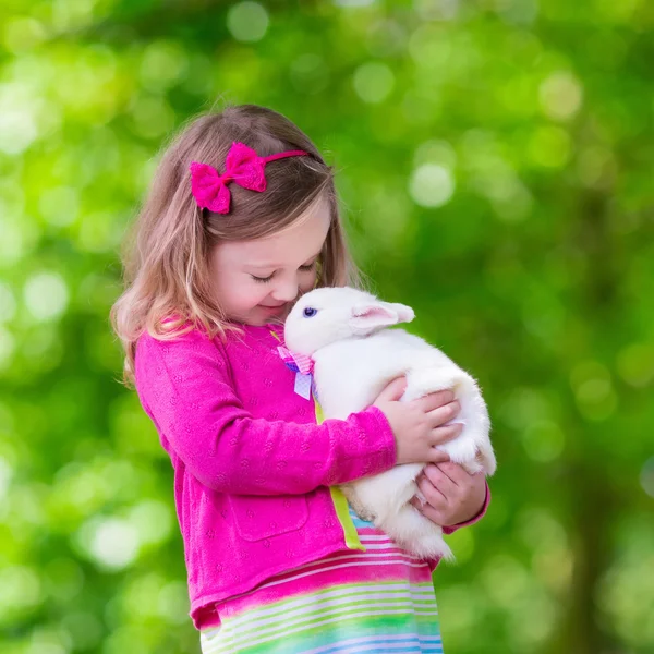 Kleines Mädchen spielt mit Kaninchen — Stockfoto