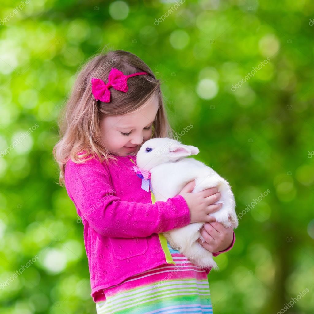 Little girl playing with rabbit — Stock Photo © FamVeldman #83909994