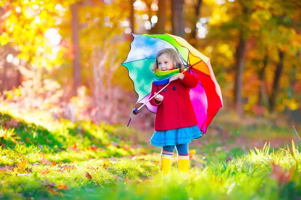 Child playing in autumn rainy park — Stockfoto