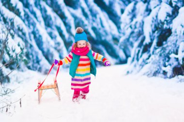 Karlı kış ormanda oynarken küçük kız