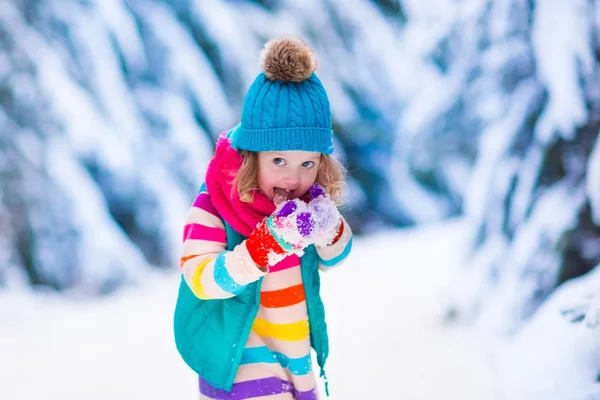 Little girl playing in snowy winter forest — Stock Photo, Image