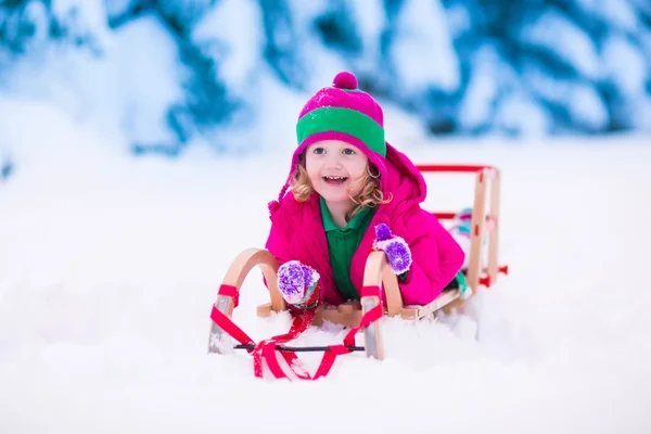 Little girl playing in snowy winter forest — Stock Photo, Image