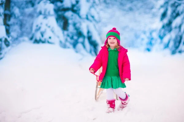 Liten flicka som leker i snörik vinter skog — Stockfoto