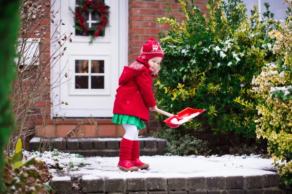 Niña paleando nieve en invierno —  Fotos de Stock