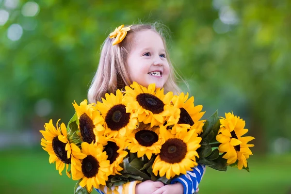 Liten flicka med solrosor — Stockfoto