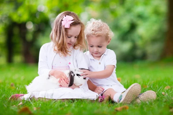 Діти грають з справжнім кроликом — стокове фото