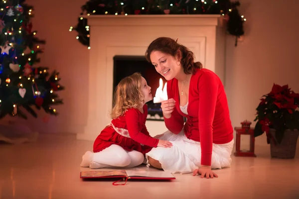 Mère et fille lisant à la cheminée la veille de Noël — Photo