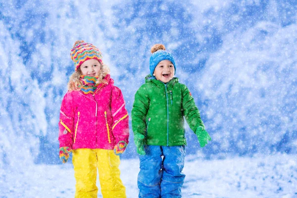Barn som leker i snöiga vinter park — Stockfoto