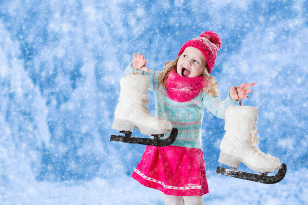 Маленькая девочка веселится на коньках зимой
