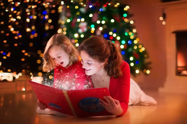 Anne ve kızı yangın yeri Noel arifesinde okuma — Stok fotoğraf