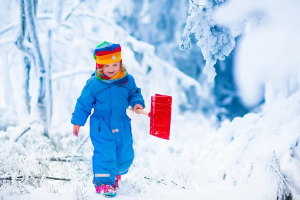 Liten flicka leker med snö på vintern — Stockfoto