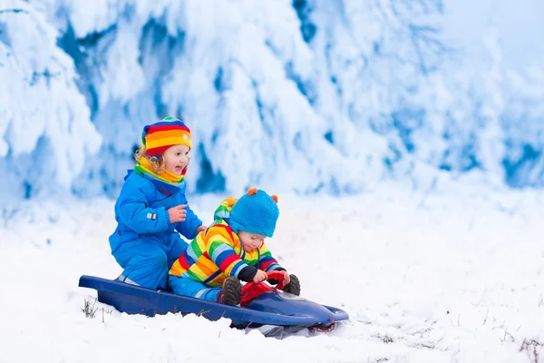 Niños divirtiéndose en un paseo en trineo en invierno — Foto de Stock