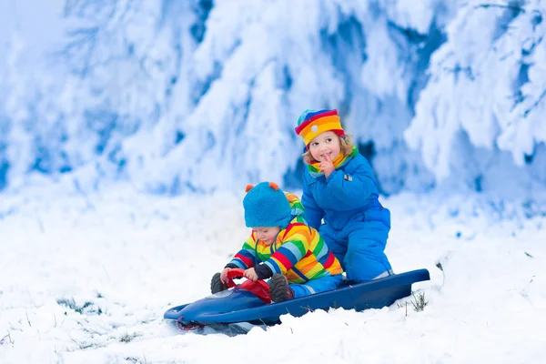 Kinderen plezier op een slee rijden in de winter — Stockfoto