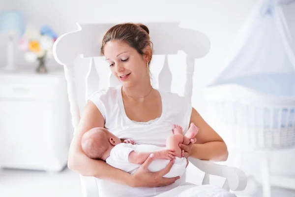 Mother and newborn baby in white nursery — Stock Photo, Image