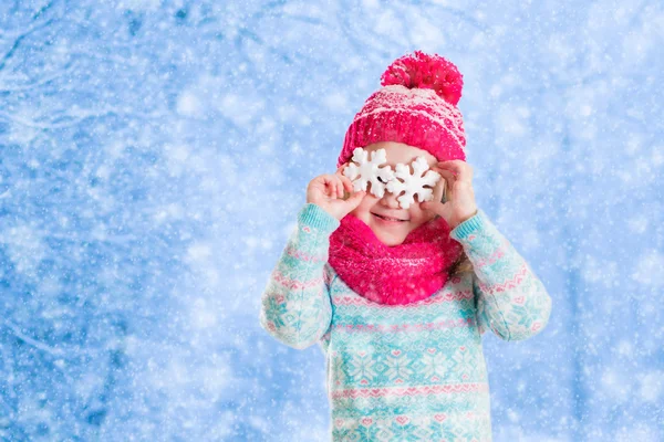 Menina brincando com flocos de neve de brinquedo no parque de inverno — Fotografia de Stock