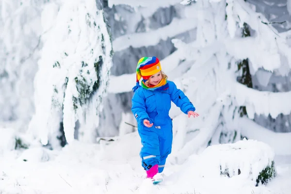 Klein meisje spelen met sneeuw in de winter — Stockfoto