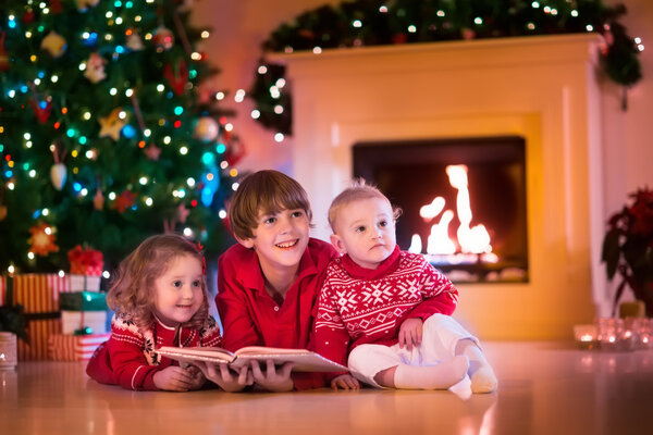 Kids playing at fireplace on Christmas eve