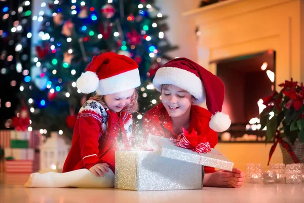 子供のクリスマス プレゼントを開ける — ストック写真