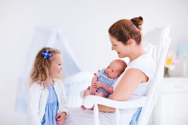 Mother with daughter and baby in a white nursery — Stock Photo, Image