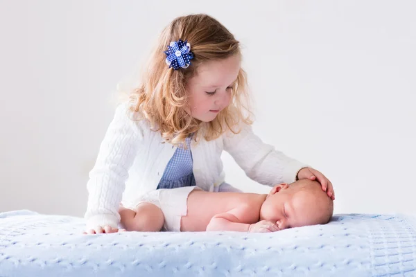 Little girl playing with newborn baby brother — Stock Photo, Image