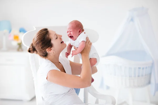 Mãe e bebê recém-nascido em berçário branco — Fotografia de Stock