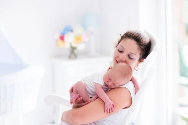 Mãe e bebê recém-nascido em berçário branco — Fotografia de Stock