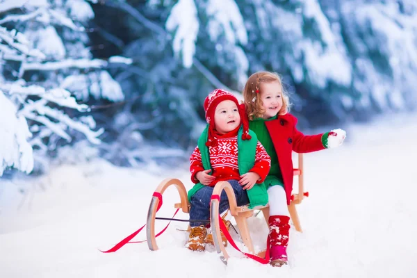 Děti baví na saních jezdit v zimě — Stock fotografie