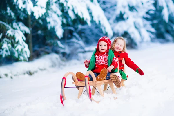 Kinderen plezier op een slee rijden in de winter — Stockfoto