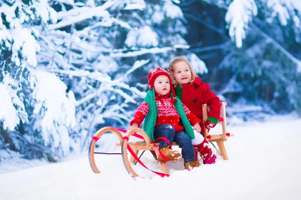 Crianças se divertindo em um passeio de trenó no inverno — Fotografia de Stock
