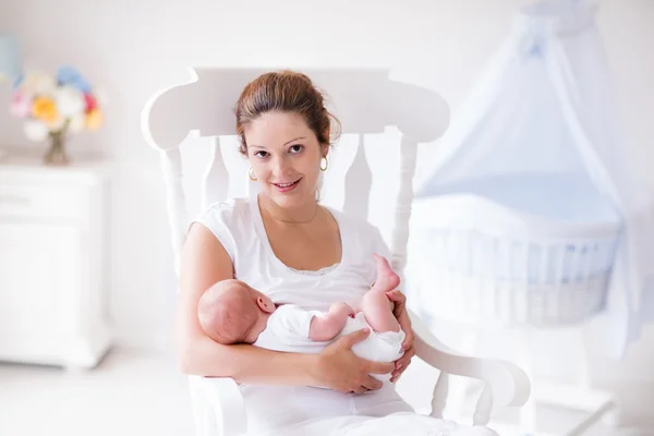 Moeder en pasgeboren baby in witte kwekerij — Stockfoto