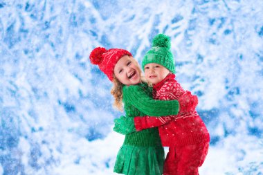 Karlı kış ormanda oynayan çocuklar