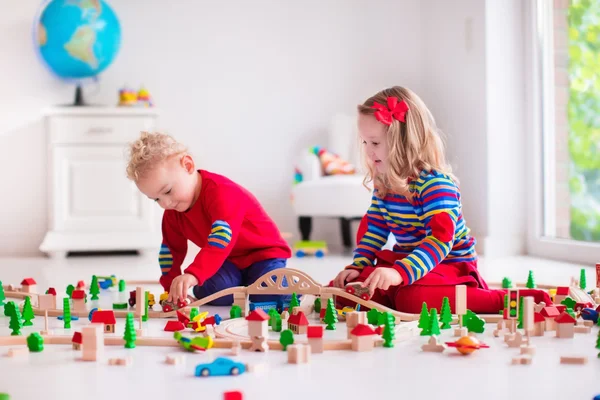 Crianças brincando com brinquedo ferroviário e trem — Fotografia de Stock