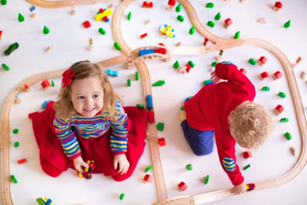 Дети играют с деревянным поездом — стоковое фото