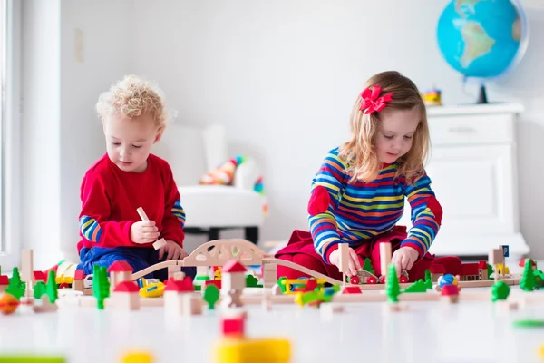 Bambini che giocano con ferrovia e treno giocattolo — Foto Stock