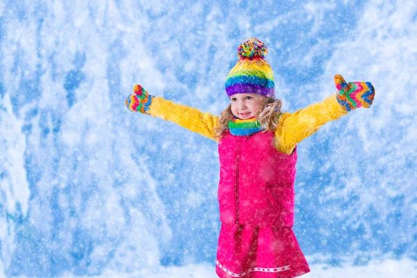 Little girl playing in snowy park — Stock Photo, Image