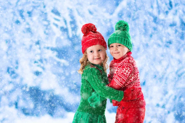 Děti hrají v zasněženém zimním lese — Stock fotografie