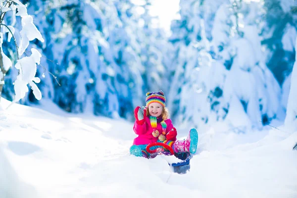 Little girl playing in snowy winter forest — Stock Photo, Image