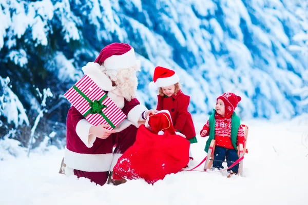 Kinder und Weihnachtsmann mit Weihnachtsgeschenken — Stockfoto