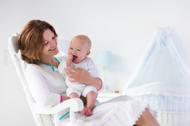 Anne ve bebek beyaz yatak odasında