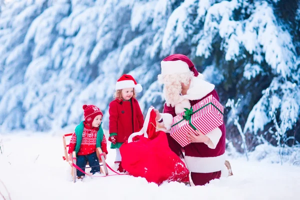 Kinder und Weihnachtsmann mit Weihnachtsgeschenken — Stockfoto